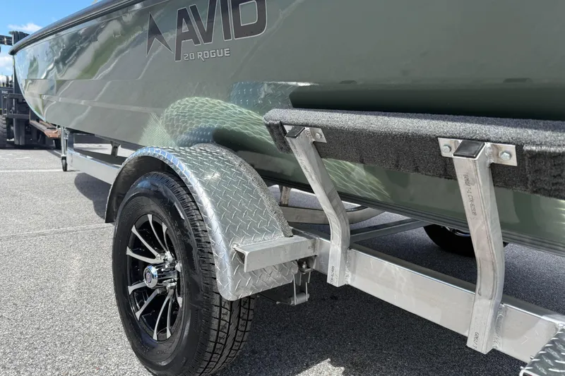 Slide: The Image of 2026 Avid 20 Rogue CC boat on a trailer with black alloy wheels. - 5