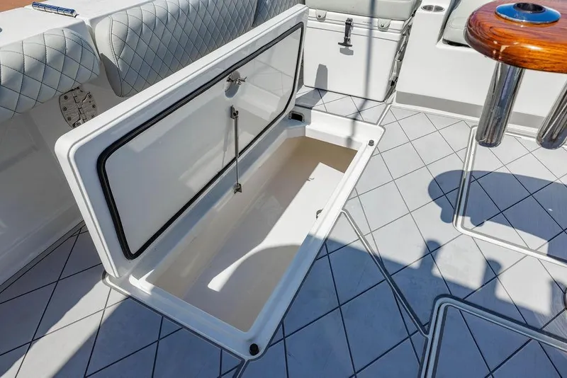 Slide: The Image of Open storage compartment on 2023 HCB 53 Suenos boat deck with quilted seating. - 27
