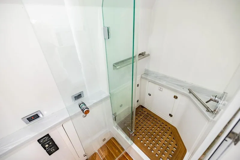 Slide: The Image of Luxurious shower area in 2023 HCB 53 Suenos boat with glass door and wooden floor. - 51