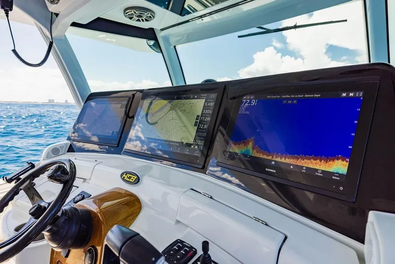 Slide: The Image of 2023 HCB 53 Suenos boat dashboard with navigation screens and steering wheel. - 64