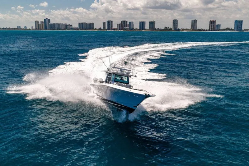 Slide: The Image of 2023 HCB 53 Suenos boat cruising on ocean with city skyline in background. - 7