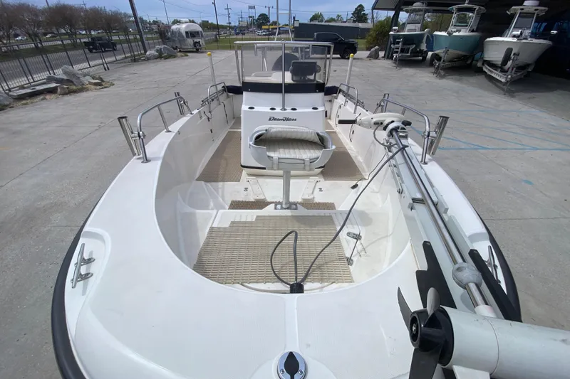 Slide: The Image of 2000 Boston Whaler Dauntless 18 boat, docked, showcasing spacious deck and seating. - 10