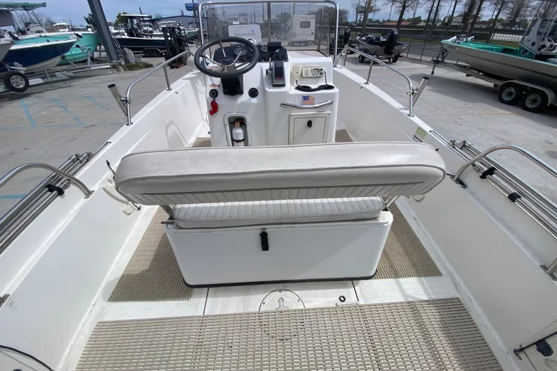 Slide: The Image of 2000 Boston Whaler Dauntless 18 boat interior with steering console and seating. - 18