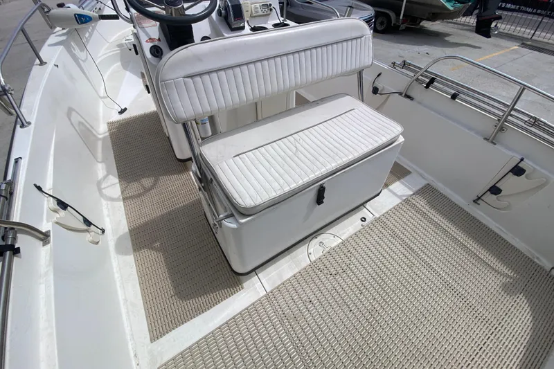 Slide: The Image of 2000 Boston Whaler Dauntless 18 interior with white seating and steering console. - 20
