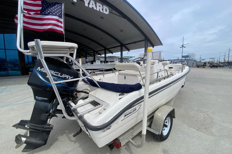 Slide: The Image of 2000 Boston Whaler Dauntless 18 boat with Mercury outboard motor, parked at a marina. - 3