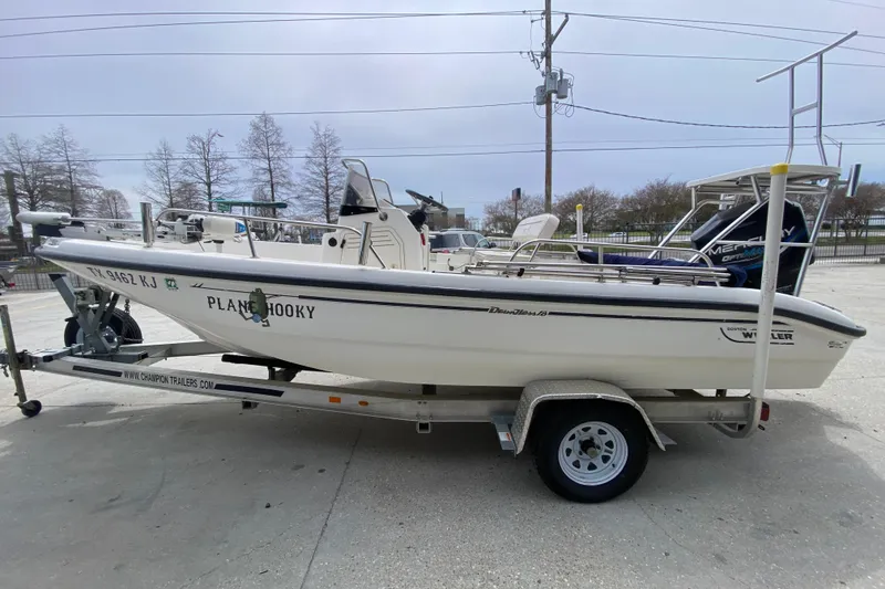 Slide: The Image of 2000 Boston Whaler Dauntless 18 boat on trailer, labeled "Plane Hooky." - 6