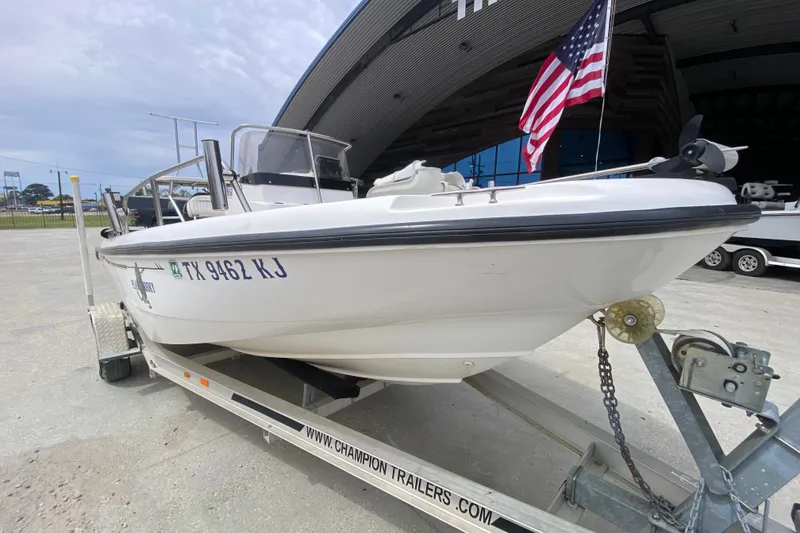 Slide: The Image of 2000 Boston Whaler Dauntless 18 boat on trailer with American flag in background. - 9