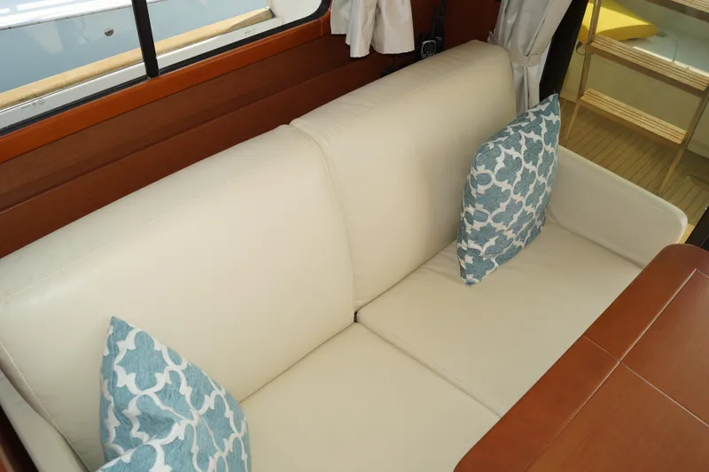Slide: The Image of Interior of 2014 Beneteau Swift Trawler 34 with cream sofa and patterned cushions. - 18