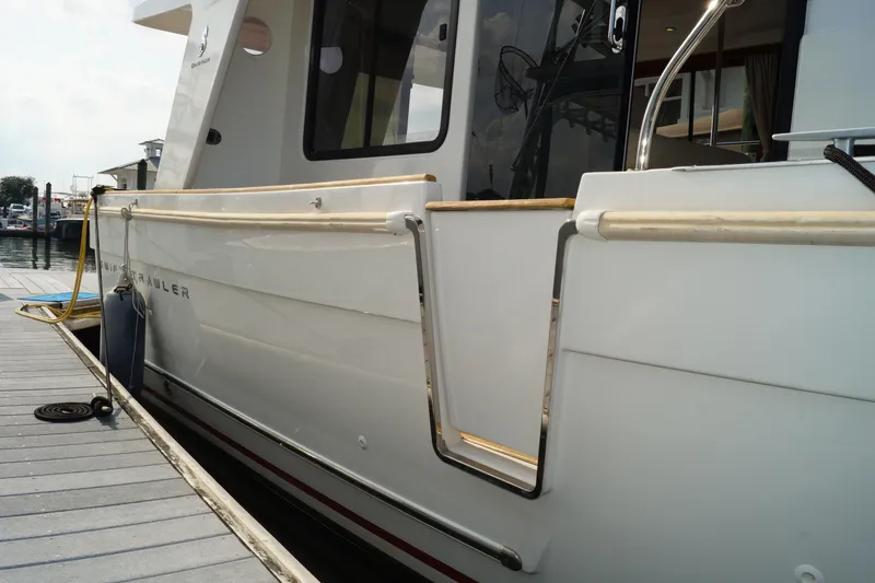 Slide: The Image of 2014 Beneteau Swift Trawler 34 docked, showcasing sleek white exterior and modern design. - 24