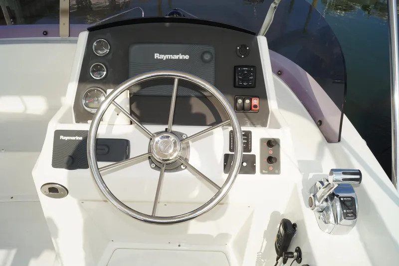 Slide: The Image of 2014 Beneteau Swift Trawler 34 helm with Raymarine navigation system and steering wheel. - 28