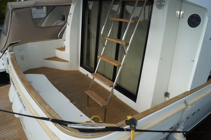 Slide: The Image of 2014 Beneteau Swift Trawler 34 with teak deck and ladder, docked at marina. - 30