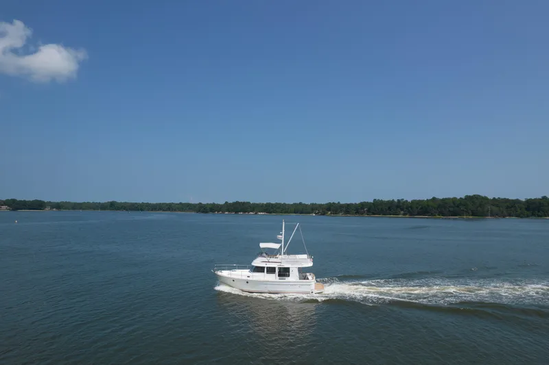 Slide: The Image of 2014 Beneteau Swift Trawler 34 cruising on a calm lake under clear blue skies. - 4