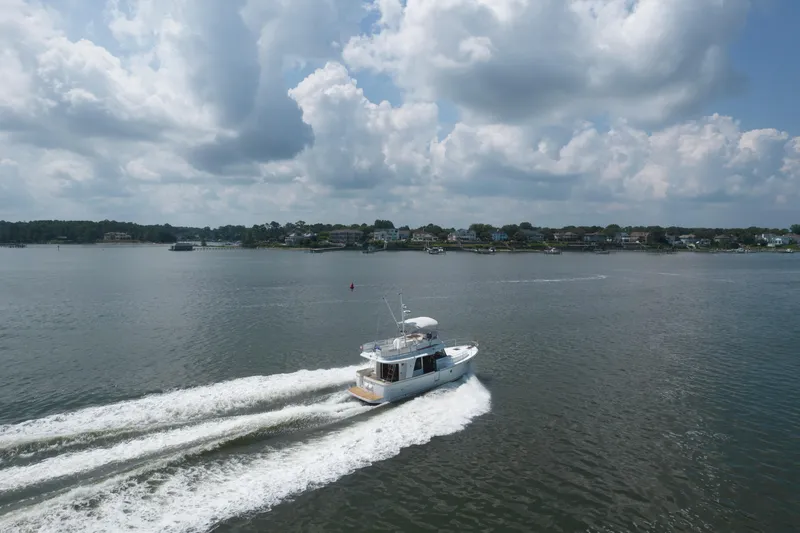 Slide: The Image of 2014 Beneteau Swift Trawler 34 cruising on a calm lake under cloudy skies. - 5