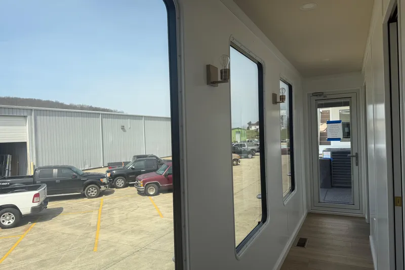 Slide: The Image of Interior view of 2026 Sumerset Voyager with large windows and parked vehicles outside. - 14