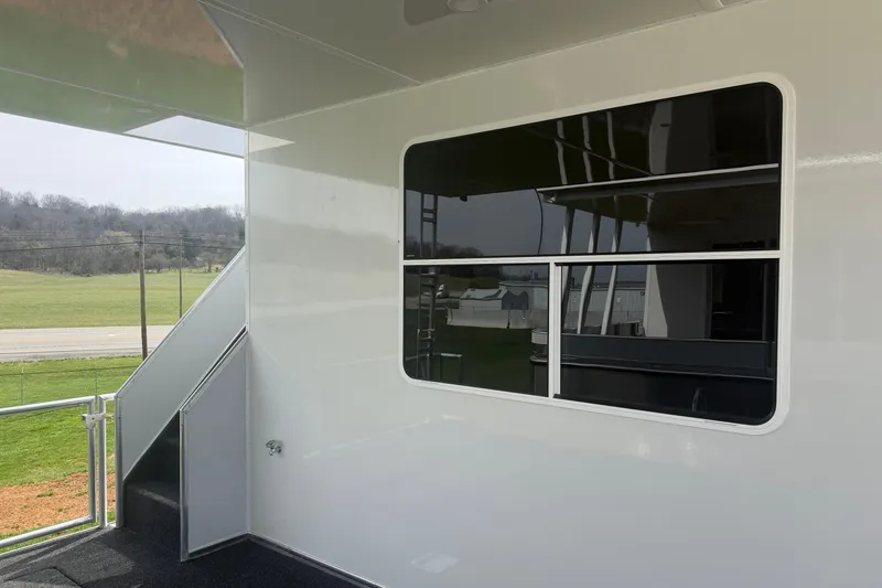 Slide: The Image of 2026 Sumerset Voyager exterior with stairs and window, showcasing modern design and countryside view. - 20