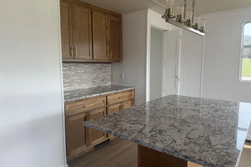 Slide: The Image of Modern kitchen interior with granite countertops and wooden cabinets in a 2026 Sumerset Voyager. - 4