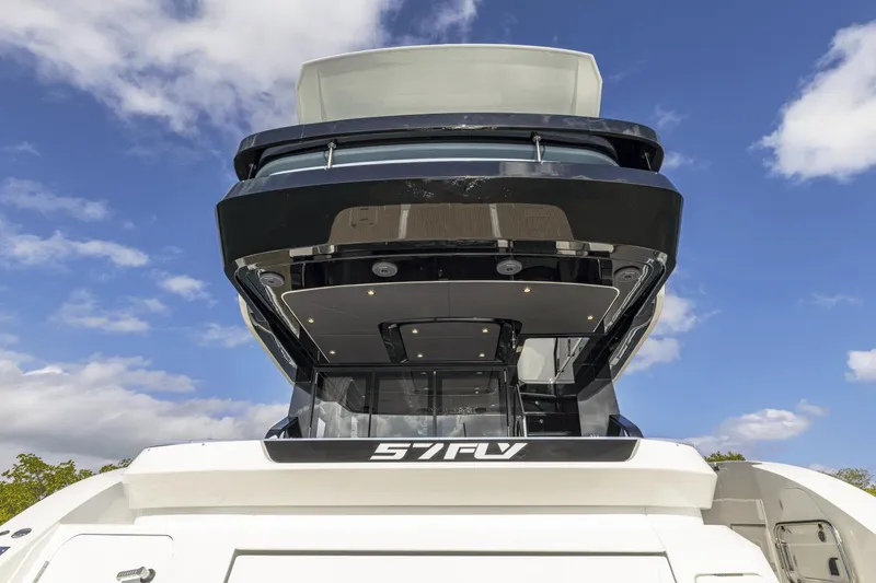 Slide: The Image of 2025 Cruisers Yachts 57 Fly, rear view against blue sky. - 11