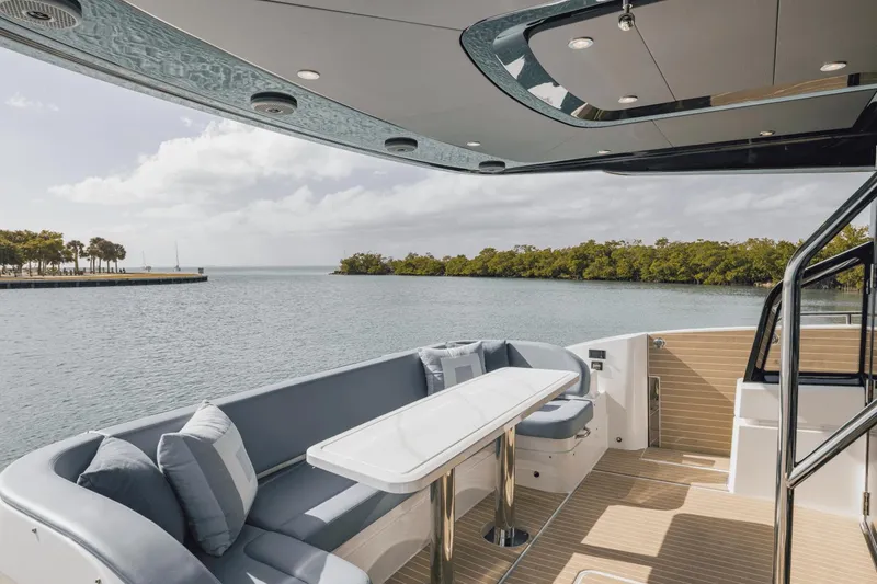 Slide: The Image of Luxurious 2025 Cruisers Yachts 57 Fly deck with elegant seating and scenic water view. - 23