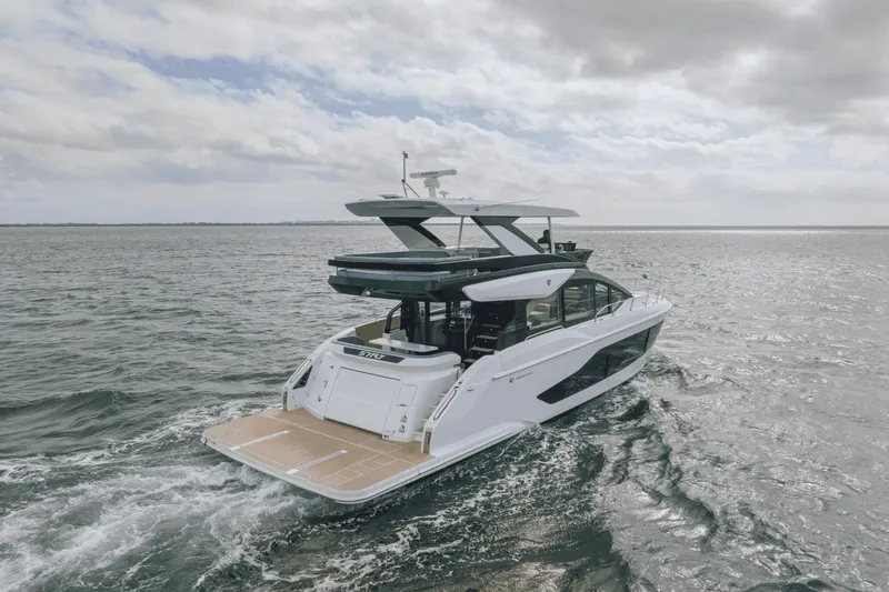 Slide: The Image of 2025 Cruisers Yachts 57 Fly navigating open waters under a cloudy sky. - 48