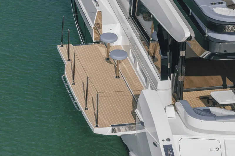 Slide: The Image of 2025 Cruisers Yachts 57 Fly, elegant deck view over calm water. - 7