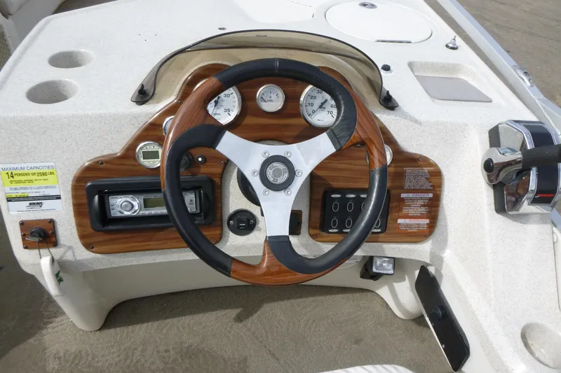 Slide: The Image of Steering console of a 2006 Harris FloteBote Crowne 250 pontoon boat with wood accents. - 11