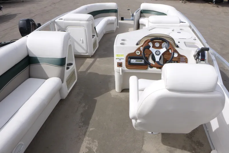 Slide: The Image of 2006 Harris FloteBote Crowne 250 pontoon boat interior with white seating and steering console. - 5