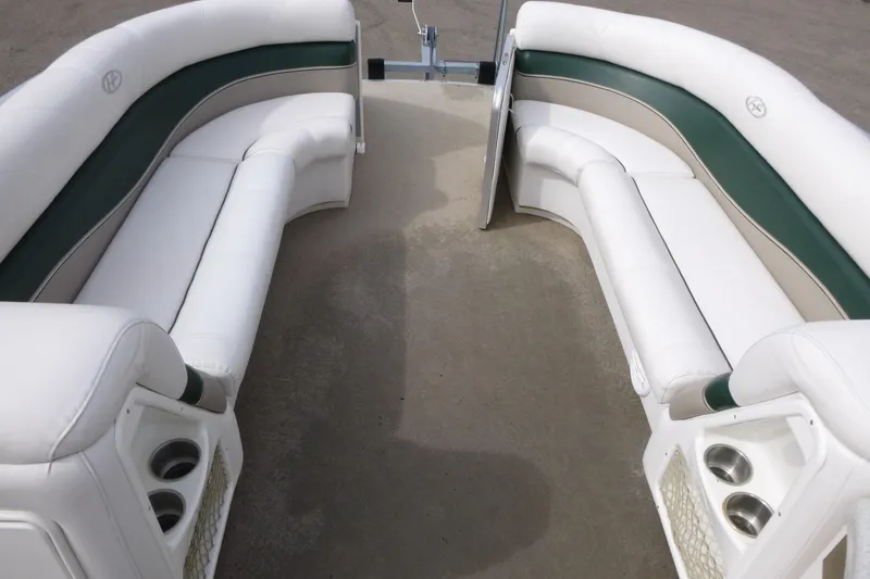 Slide: The Image of 2006 Harris FloteBote Crowne 250 interior with white and green seating, cup holders visible. - 6