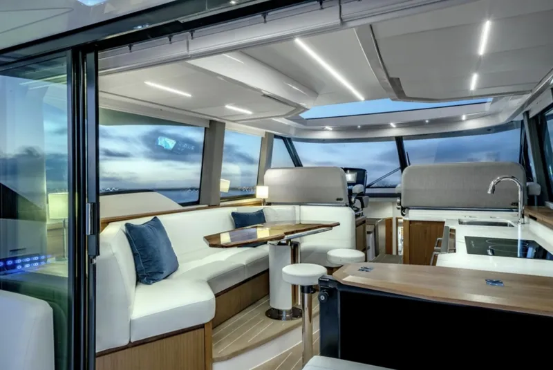 Slide: The Image of 2024 Tiara Yachts EX 60 interior with modern seating, dining area, and panoramic windows. - 27