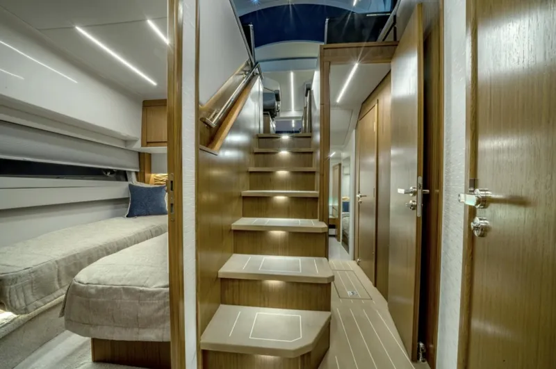 Slide: The Image of 2024 Tiara Yachts EX 60 interior with modern wooden staircase and cozy sleeping area. - 49