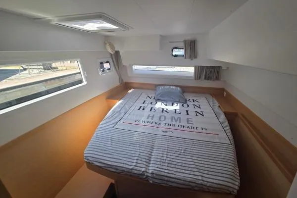 Slide: The Image of Cozy cabin interior of 2018 Lagoon 42 catamaran with striped bedding and scenic windows. - 10
