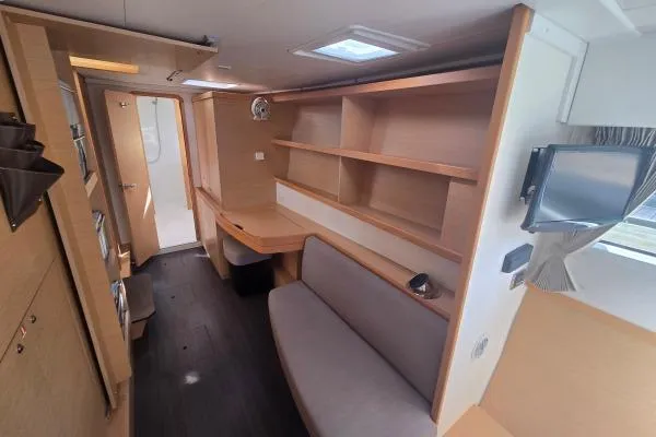 Slide: The Image of Interior of a 2018 Lagoon 42 catamaran featuring modern wood finishes and a cozy seating area. - 11