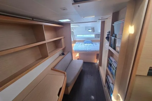 Slide: The Image of Interior of 2018 Lagoon 42 catamaran with cozy cabin, bed, and wooden shelves. - 12