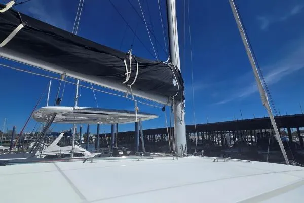 Slide: The Image of 2018 Lagoon 42 catamaran with sails down, docked under clear blue sky. - 17