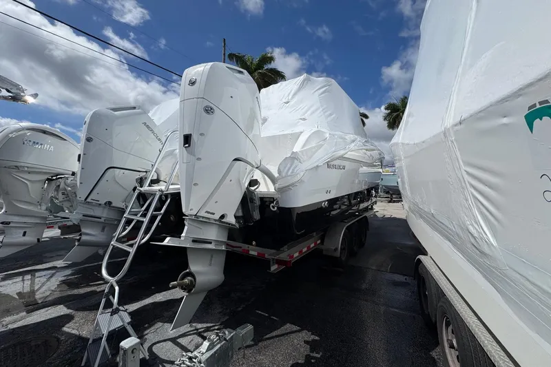 Slide: The Image of 2026 World Cat 325 CC boat on trailer, covered, with outboard motors. - 2