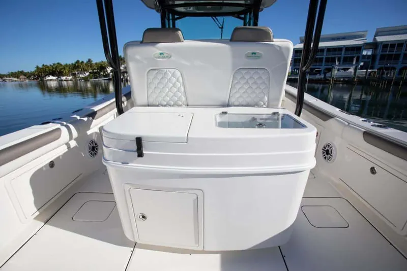 Slide: The Image of Manufacturer Provided Image: 2026 World Cat 325 CC boat interior with seating and storage, docked by calm waters. - 28