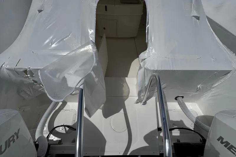 Slide: The Image of 2026 World Cat 325 CC boat interior with protective covering and Mercury engines. - 3