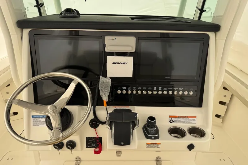 Slide: The Image of Helm of 2026 World Cat 325 CC boat with dual Garmin displays and Mercury controls. - 4
