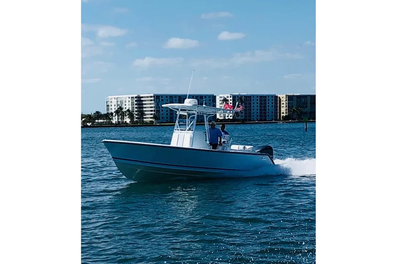 The Image of 2015 Stuart 26 boat docked in a scenic marina with lush greenery. - 0