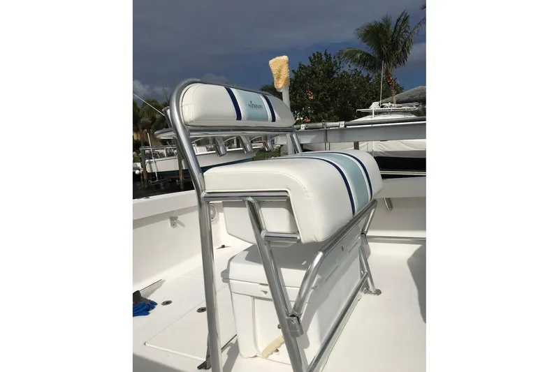 Slide: The Image of Interior of a 2015 Stuart 26 boat with cushioned seating and built-in speakers. - 10