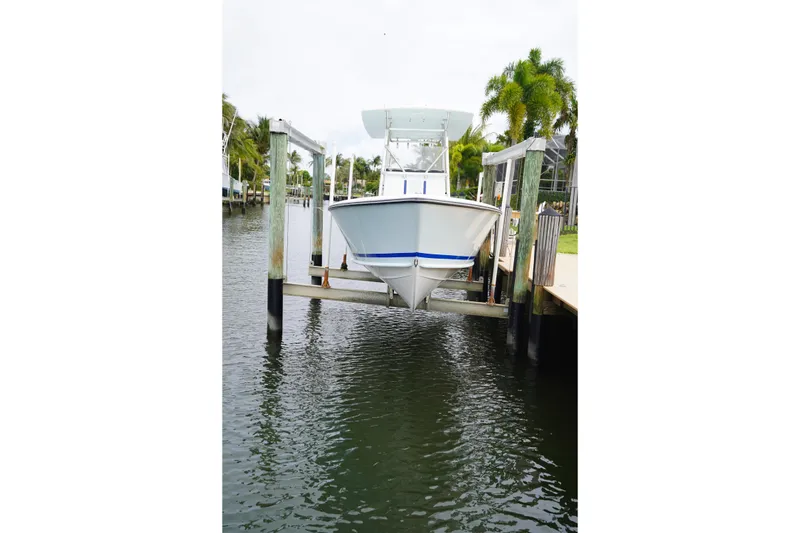 Slide: The Image of 2015 Stuart 26 boat docked on a lift by a waterfront. - 21