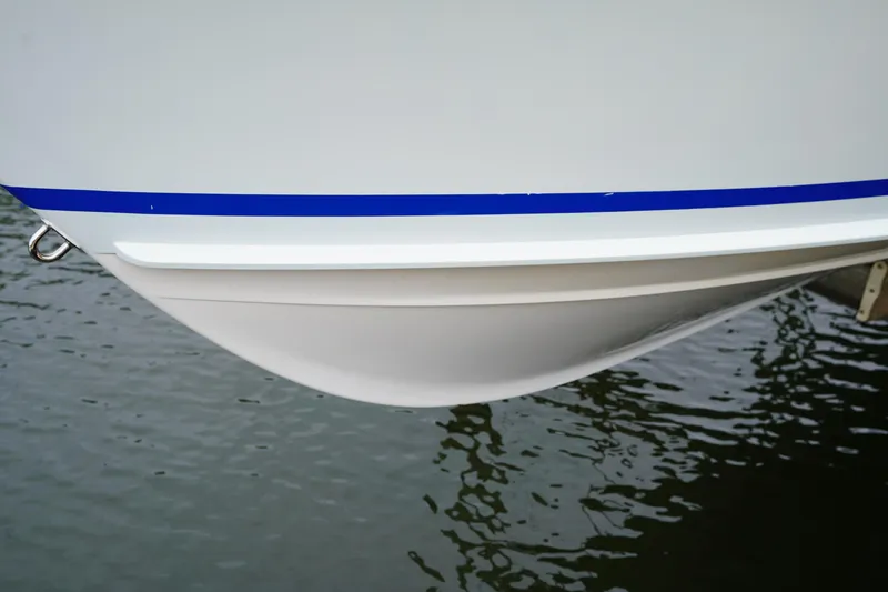 Slide: The Image of Close-up of 2015 Stuart 26 boat hull with blue stripe on water. - 22