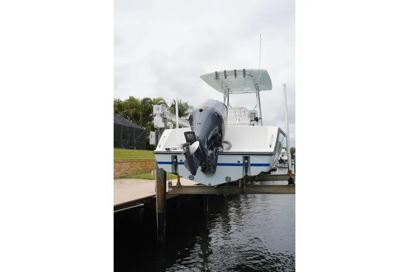 Slide: The Image of Stuart 26 boat from 2015 docked, featuring an outboard motor and canopy. - 23