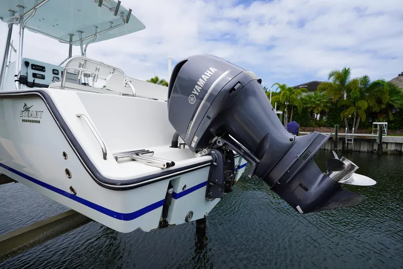 Slide: The Image of Stuart 26 boat with Yamaha outboard motor, docked near lush greenery, 2015 model. - 26