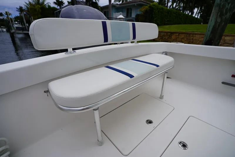 Slide: The Image of White seating on a 2015 Stuart 26 boat, docked near a waterfront home. - 30