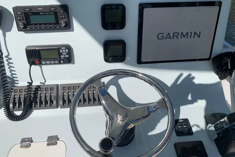 Slide: The Image of 2015 Stuart 26 boat on lift by waterfront, featuring Yamaha outboard motor. - 4