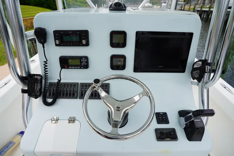 Slide: The Image of Control panel of a 2015 Stuart 26 boat with steering wheel and navigation equipment. - 43