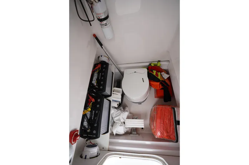 Slide: The Image of Interior of a 2015 Stuart 26 boat showing batteries, toilet, and safety equipment. - 48