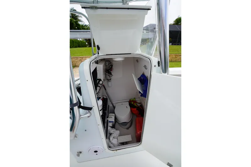 Slide: The Image of Interior view of a 2015 Stuart 26 boat's compact bathroom with toilet and storage. - 49