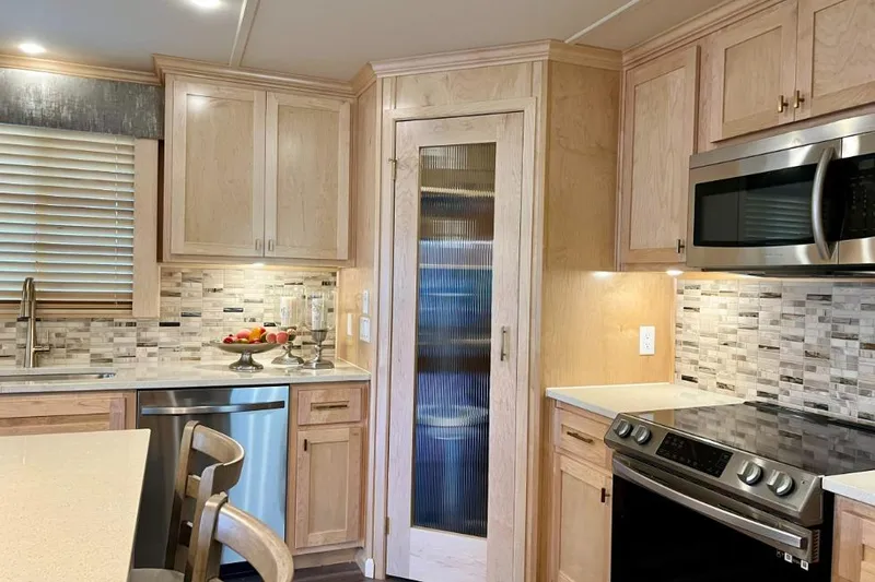 Slide: The Image of Modern kitchen in 2026 Sumerset Luxe I houseboat with stainless steel appliances and wooden cabinetry. - 4