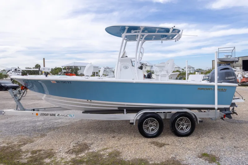 Slide: The Image of 2023 Sportsman Masters 227 Bay Boat on trailer, blue hull, outdoor setting. - 15